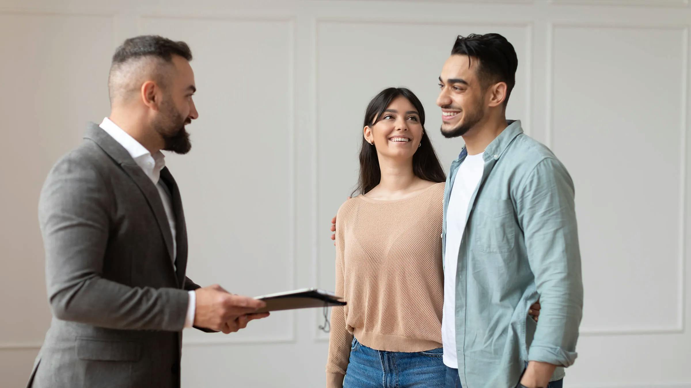 Real estate agent showing property for young buyers