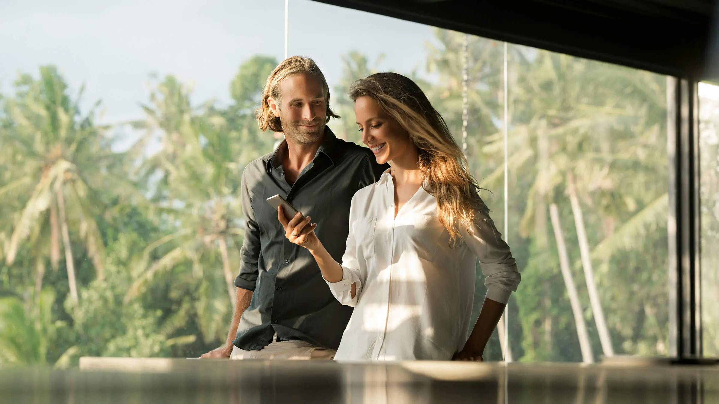 Smiling couple with smartphone in design house